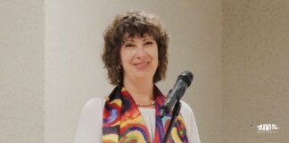 Adriana Holender w barwnym szalu i białej bluzce