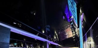 uczestniczka domówki śpiewa karaoke, w tle ekran z wyświetlanym tekstem oraz publiczność