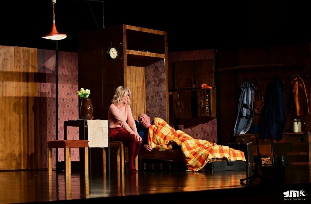 bohaterowie spektaklu - on leży chory w łóżku, ona - siedzi, pocieszając go