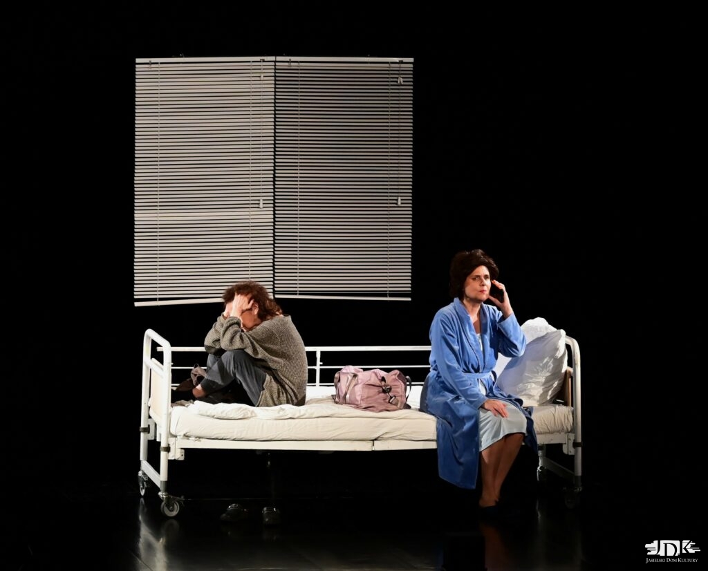 dwie kobiety siedzące na łóżku. W tle żaluzja