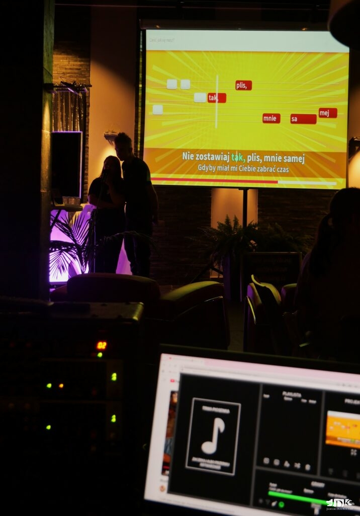 konsola a w tle ekran z wyświetlanym tekstem