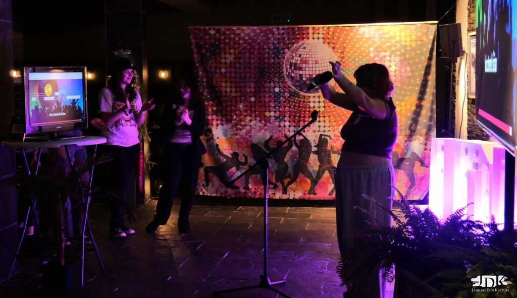 uczestniczka karaoke tańczy, śpiewając