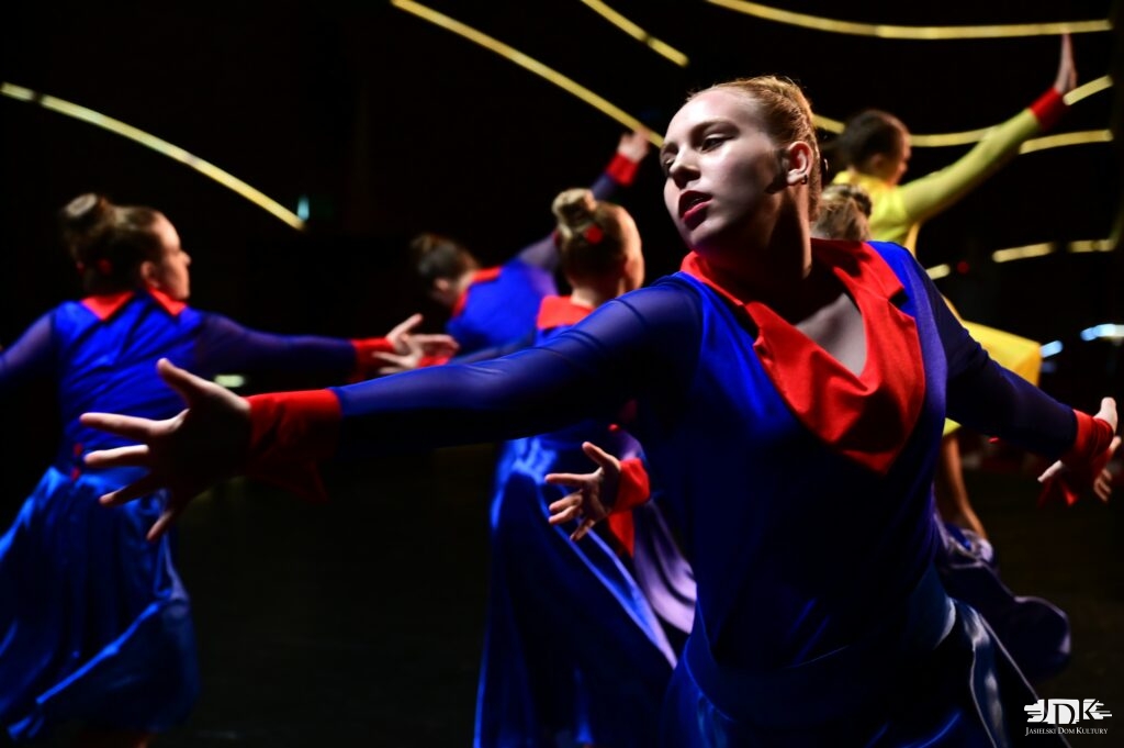 zbliżenie na tancerkę w niebiskiej sukience i kołnierzu