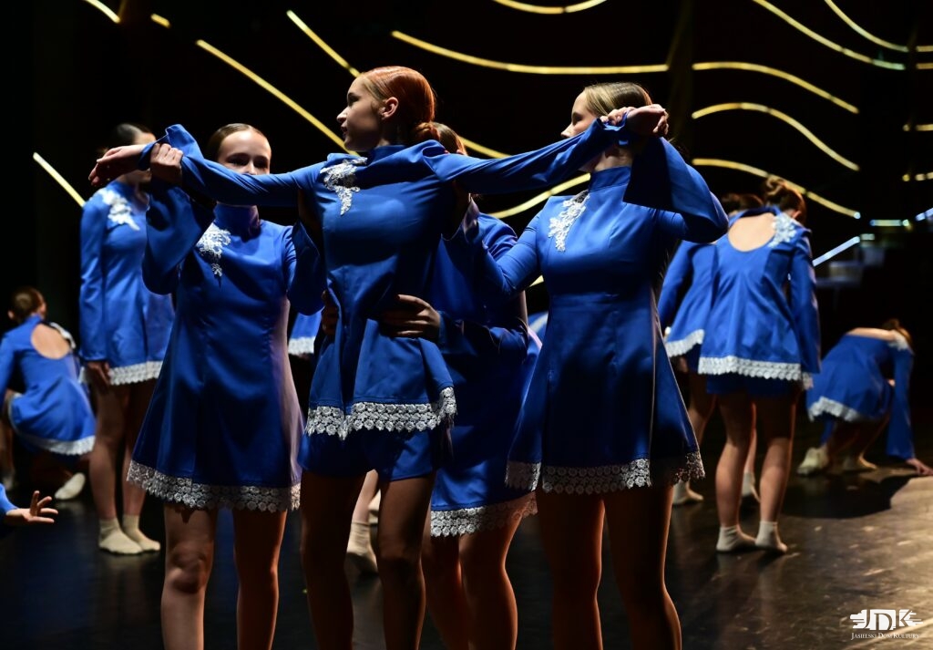 tancerki w niebieskich strojach unoszą jedną z nich