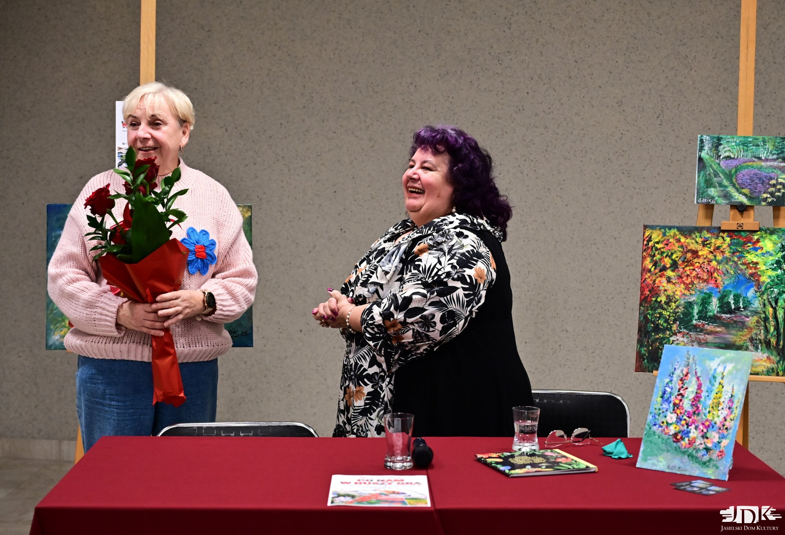 uśmiechnięta malarka i pani Elżbieta wręczająca kwiaty