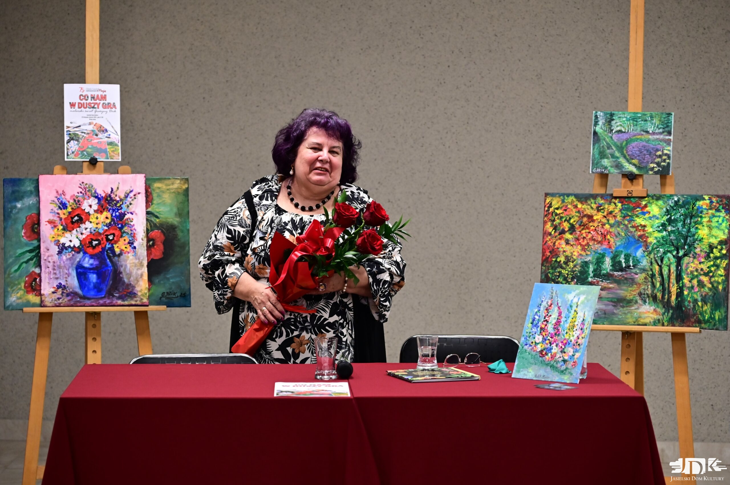 malarka uśmiecha się, trzymając kwiaty