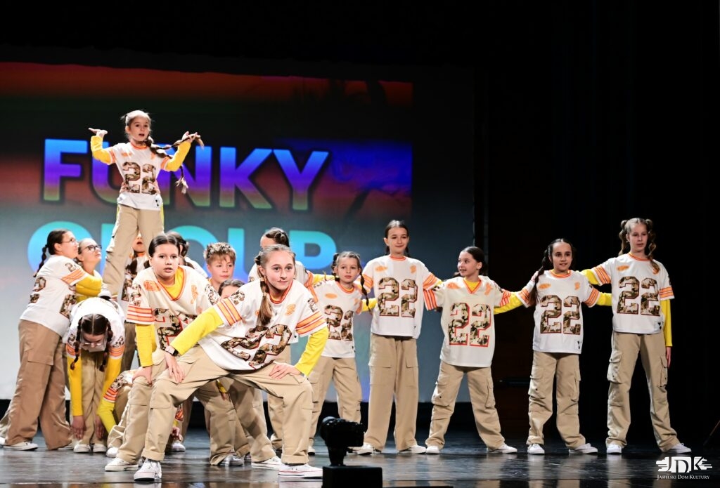 grupa tancerzy unosi tancerkę