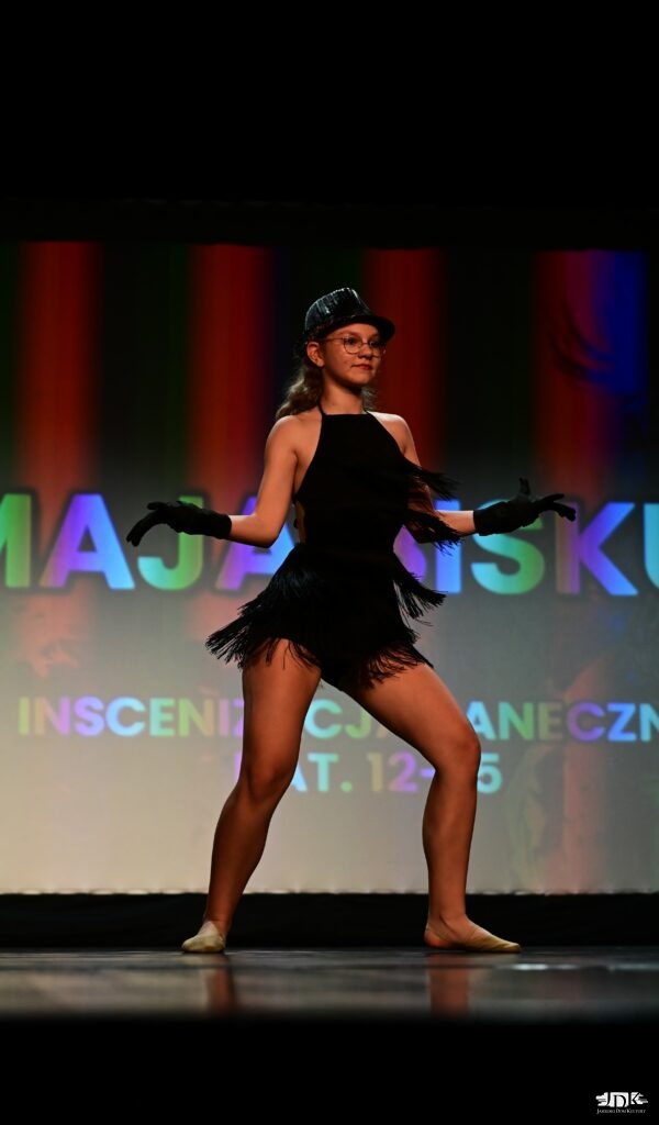 tancerka w sukience z frędzlami i kapeluszu z czarnych cekinów