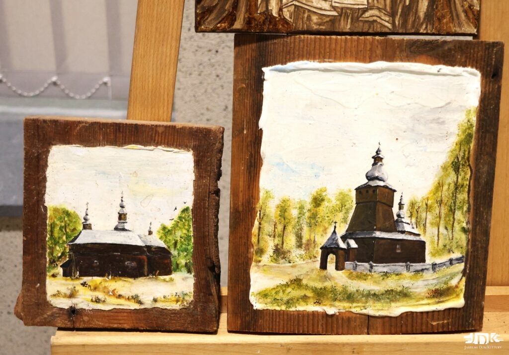 dwa obrazy na drewnie przedstawiające tę samą drewnianą cerkiew na tle lasu