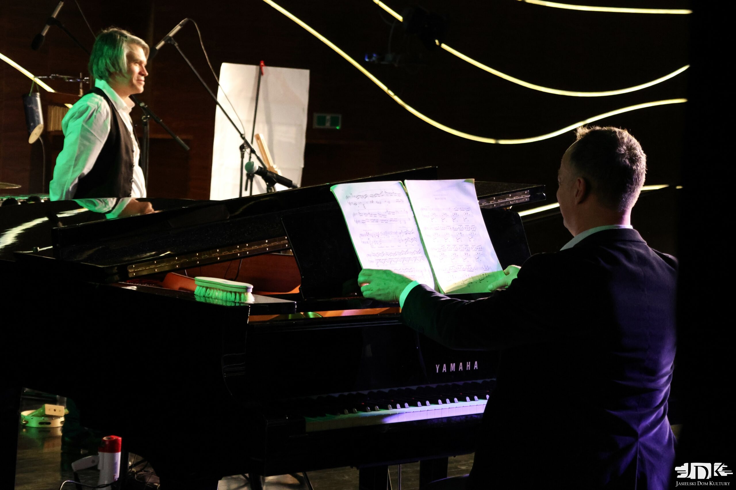 fortepian Yamaha oraz muzyk otwierający nuty
