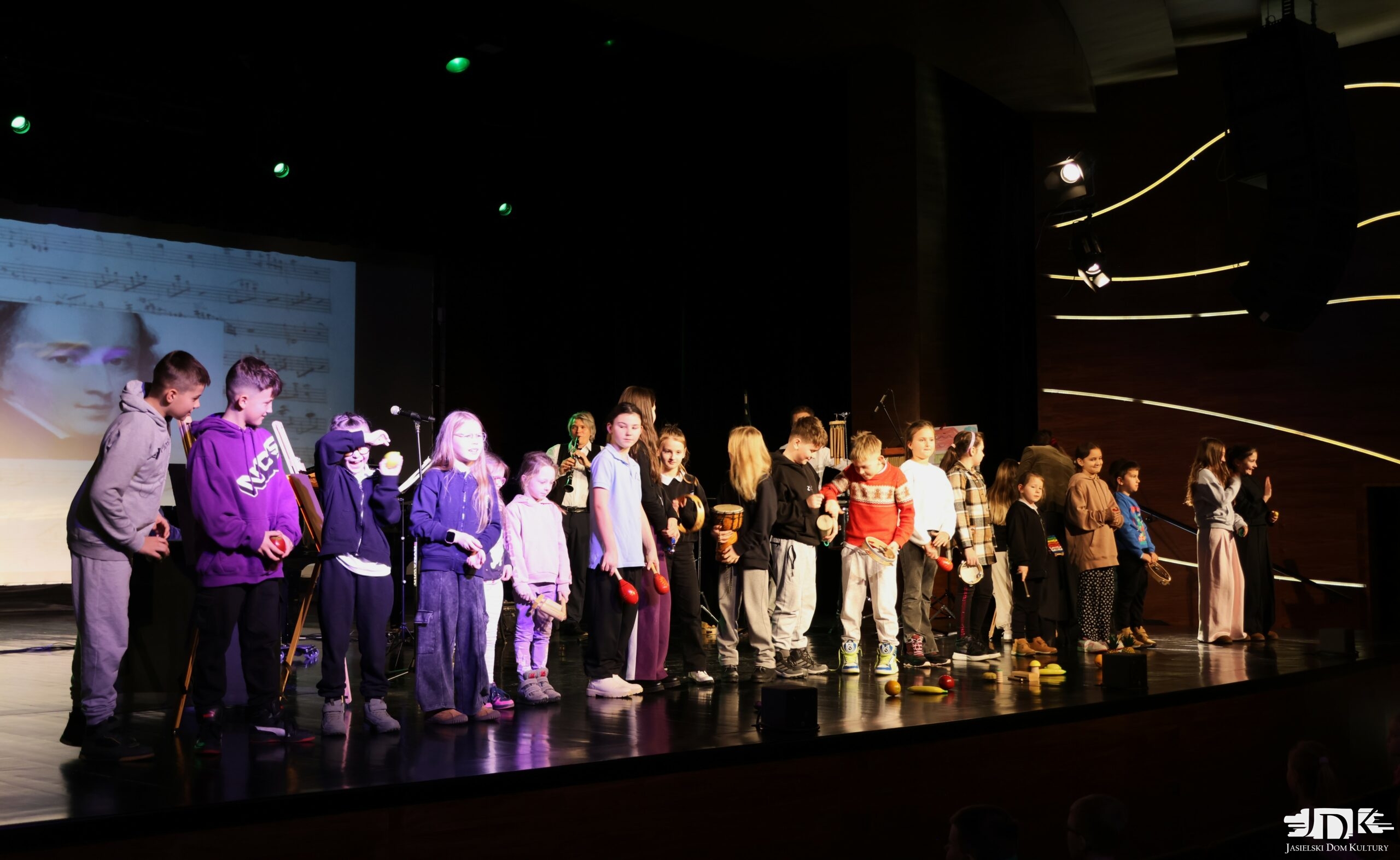 cała grupa ochotników z widowni na scenie, w rękach trzymają instrumenty: grzechotki, marakasy, tamburyny, bongosy