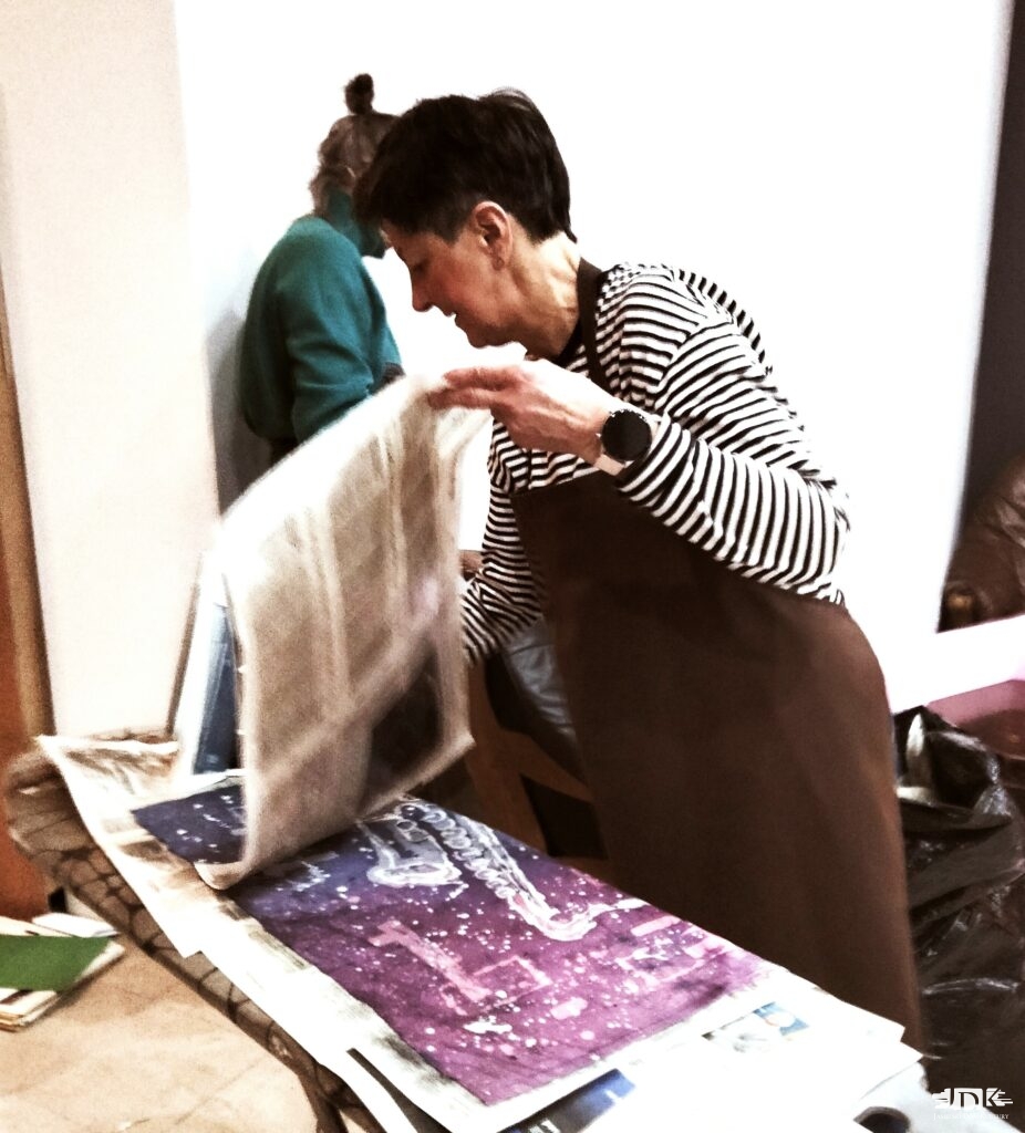 pani prasuje materiał zakrywając go gazetą