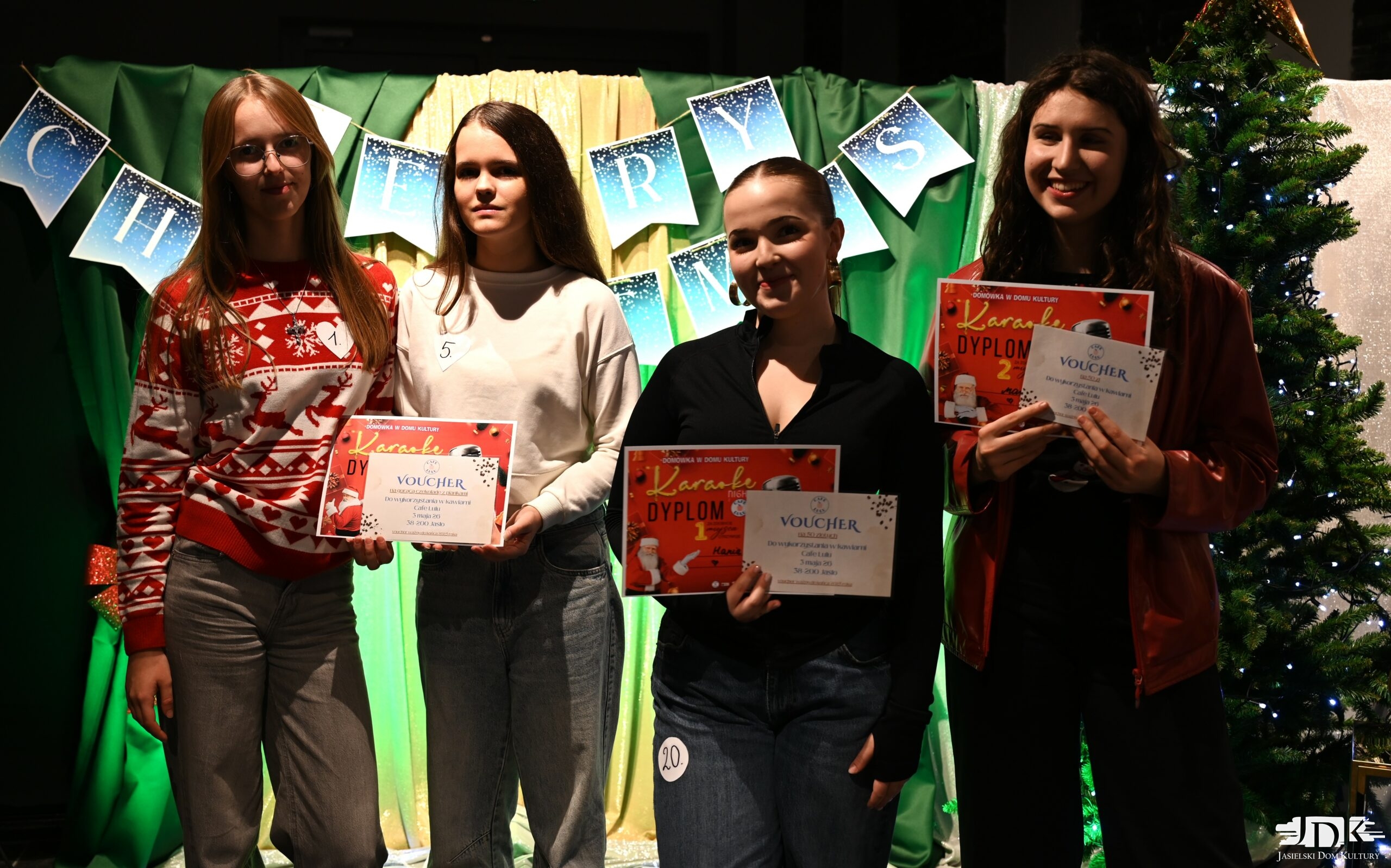 cztery uśmiechnięte zwyciężczynie w konkursie karaoke trzymające czerwone dyplomy za wygraną w konkursie oraz vouchery od CAFE LULU