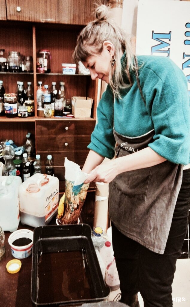 uczestniczka zajęć roztapia wosk w topiarce