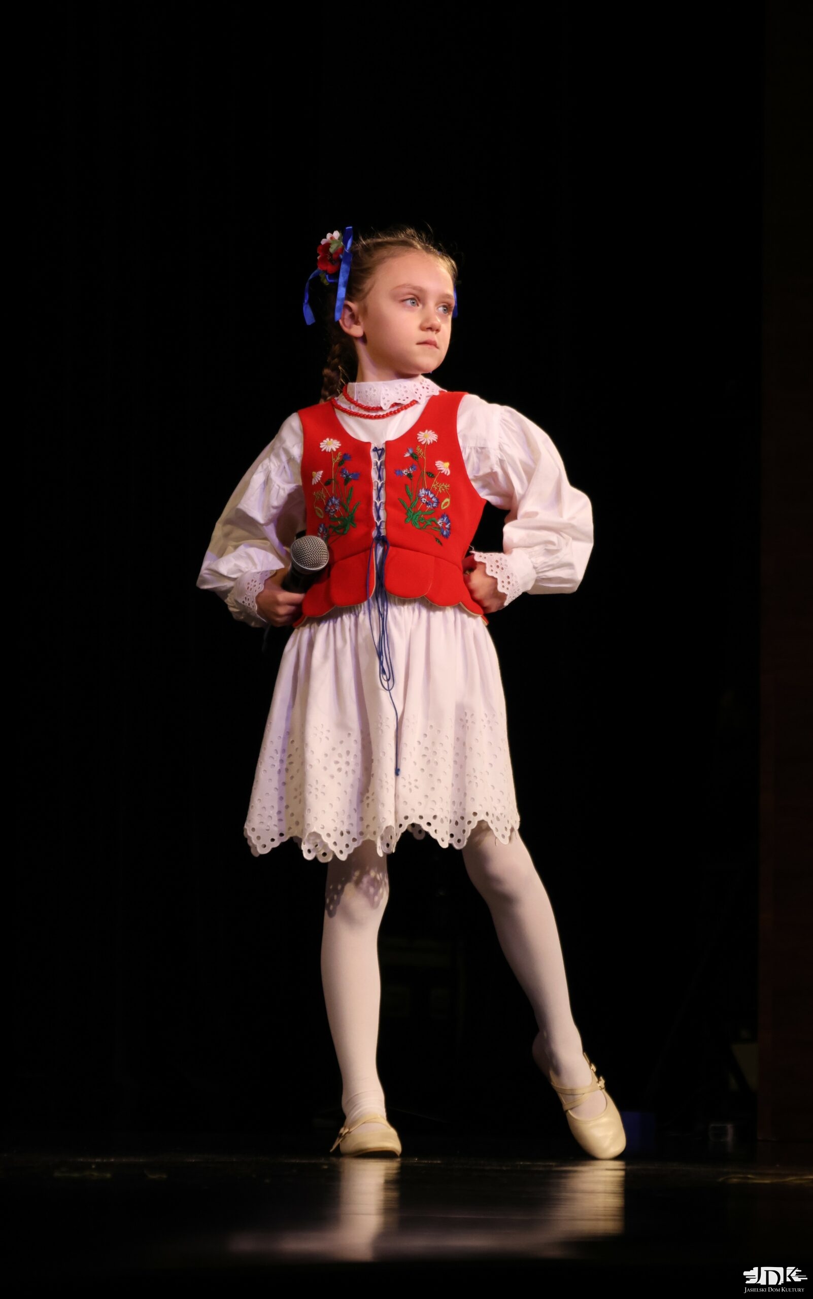 dziewczynka w stroju regionalnym ze wstążkami we włosach