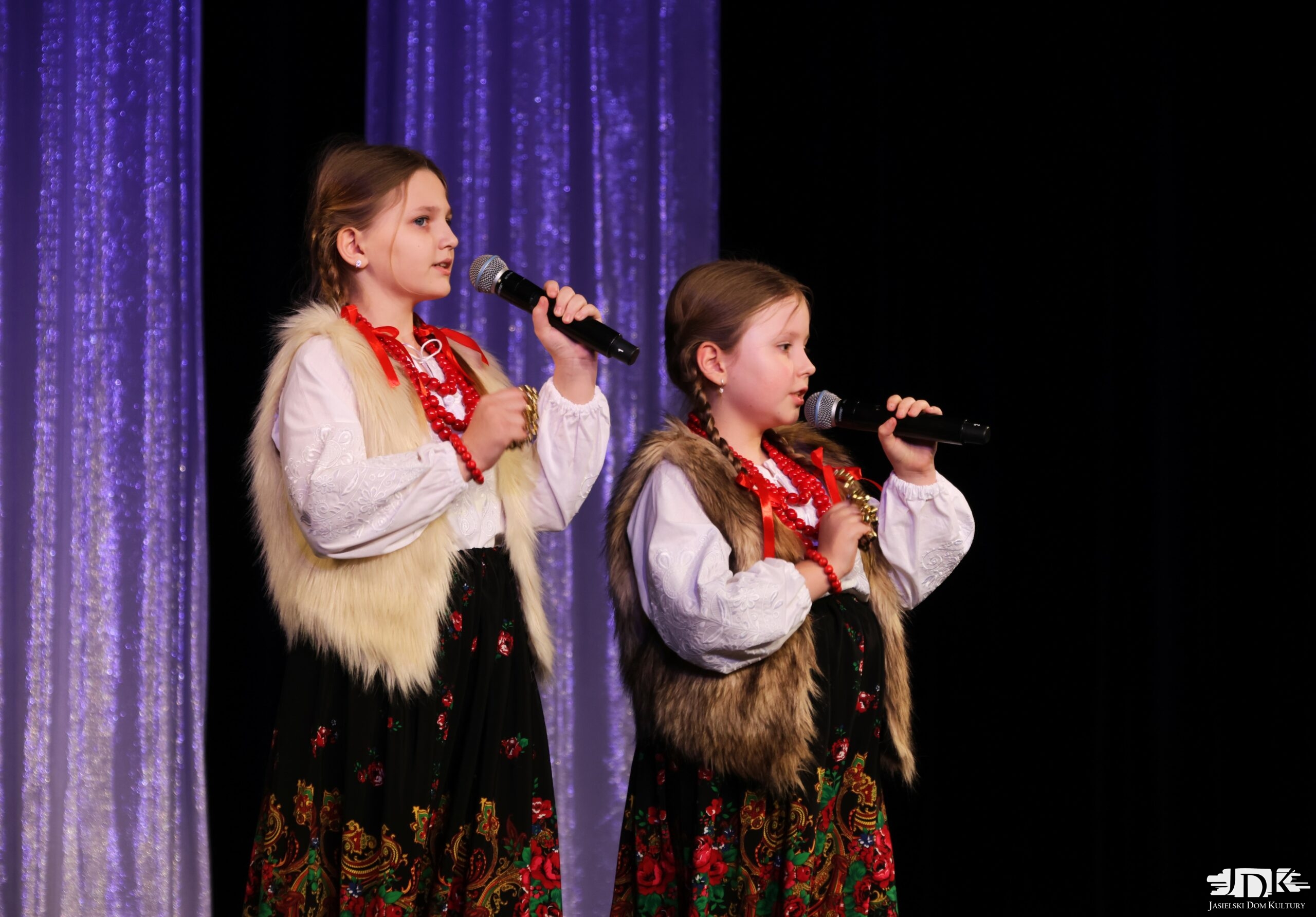 duet dwóch dziewcząt w regionalnych strojach i futrzanych kamizelkach