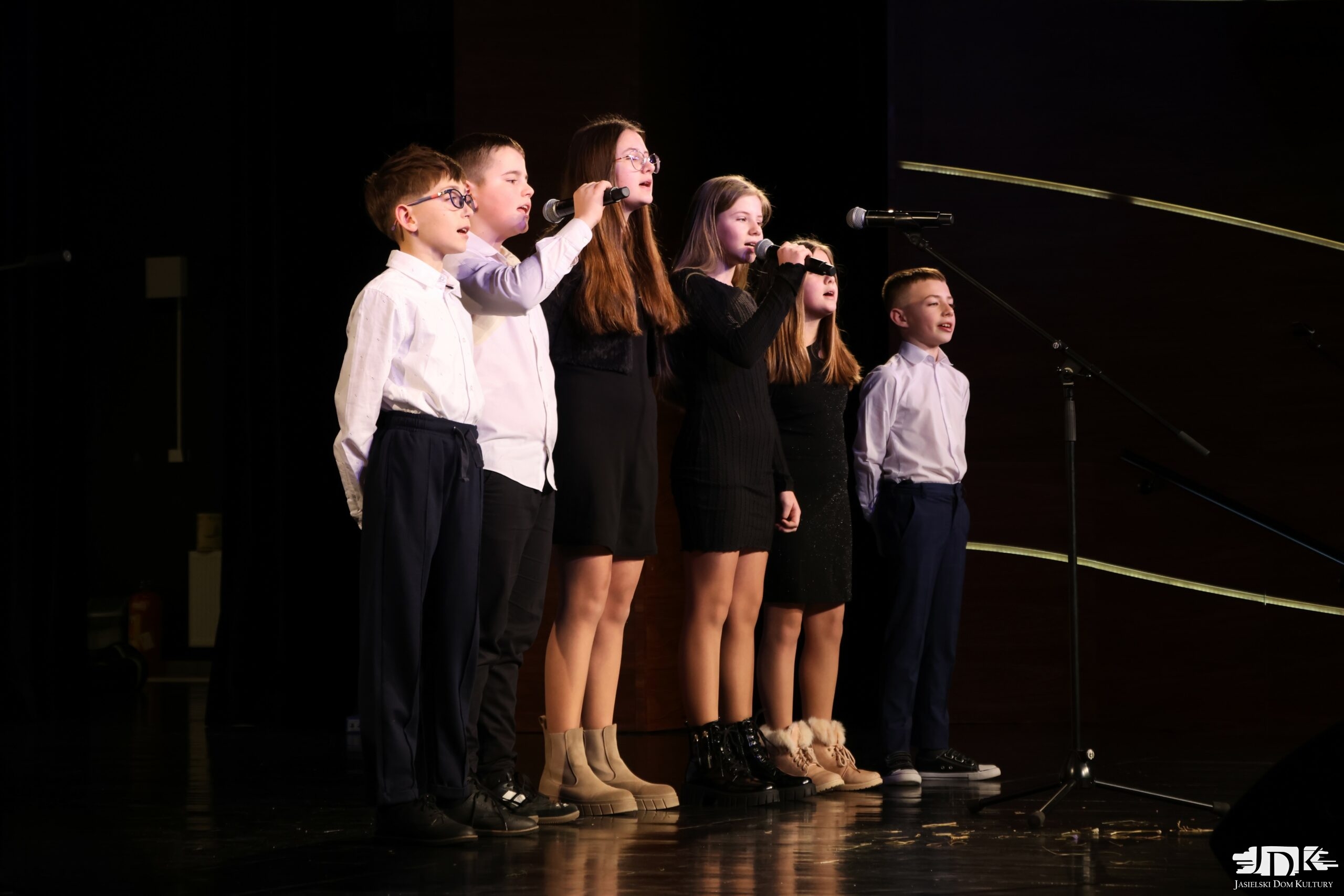 zespół wokalny - troje chłopców w białych koszulach i czarnych spodniach oraz trzy dziewczyny w czarnych sukienkach