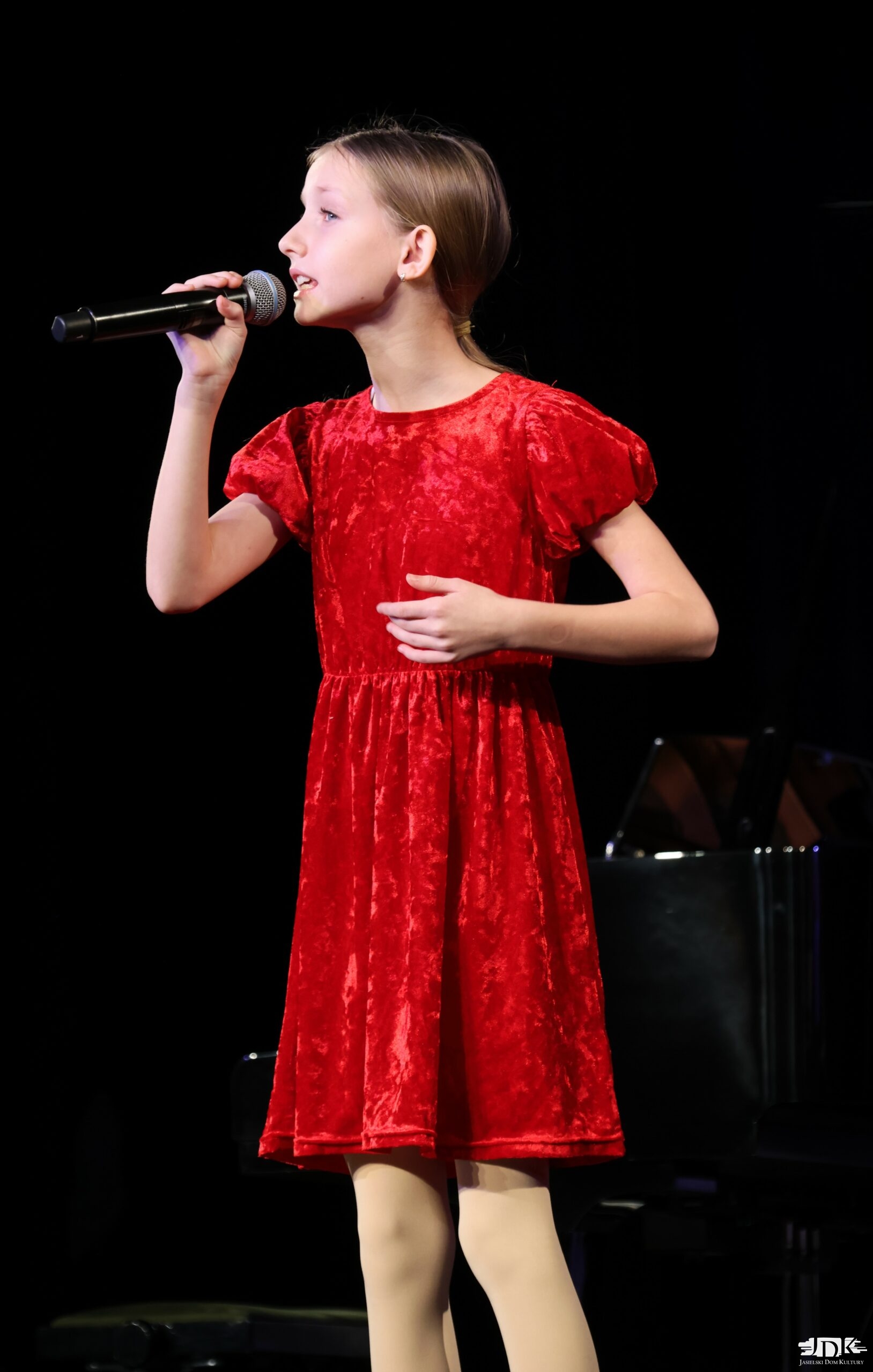 dziewczynka w kucyku w czerwonej welurowej sukience