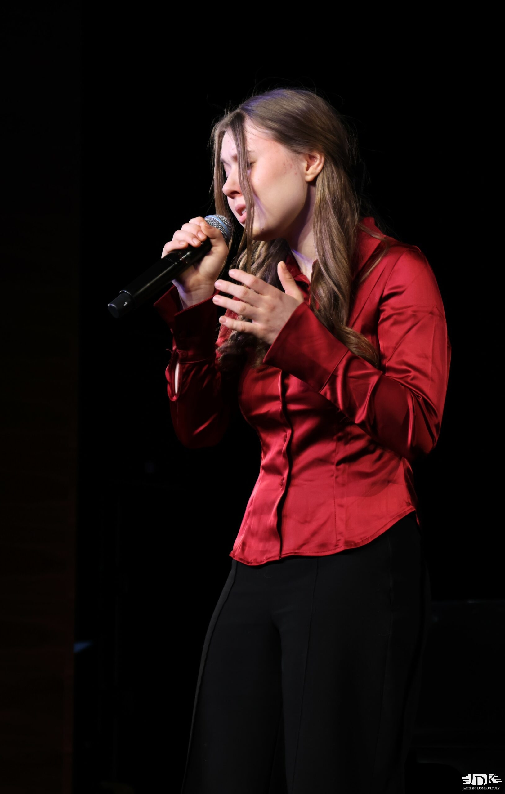 dziewczynka w czerwonej atłasowej bluzce i czarnych spodniach