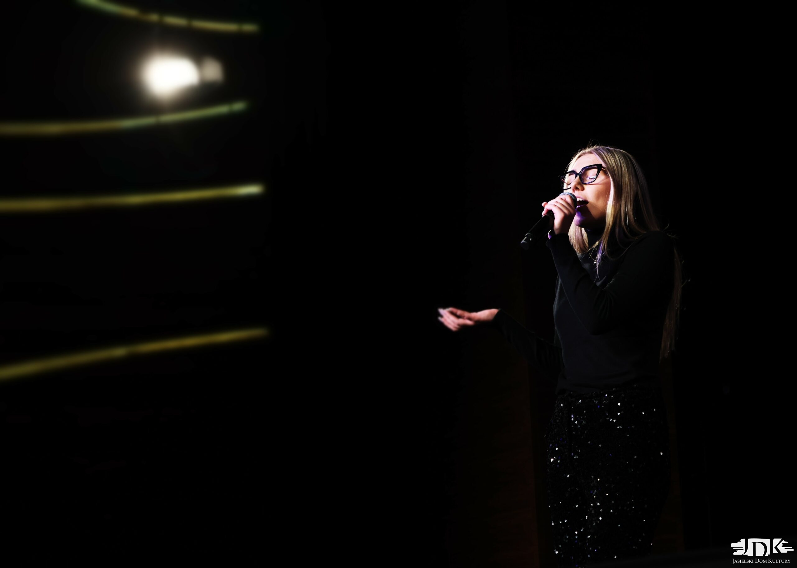 dziewczyna w czarnych cekinowych spodniach, czarnej bluzce i czarnych dużych okularach