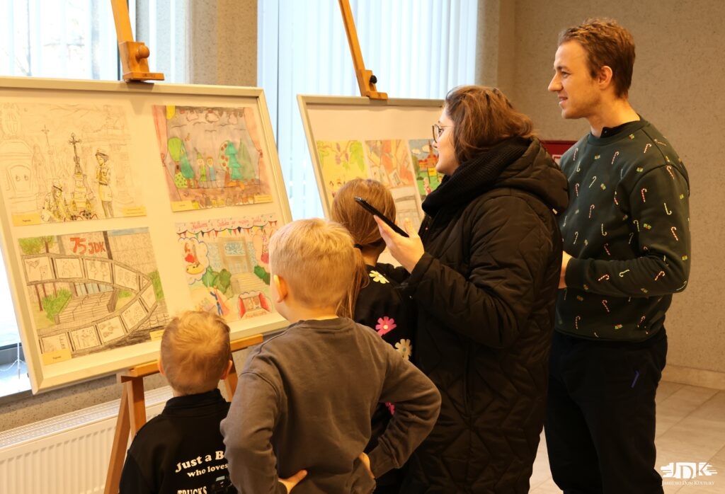 rodzice z trójką dzieci oglądający kolorowe prace na sztalugach