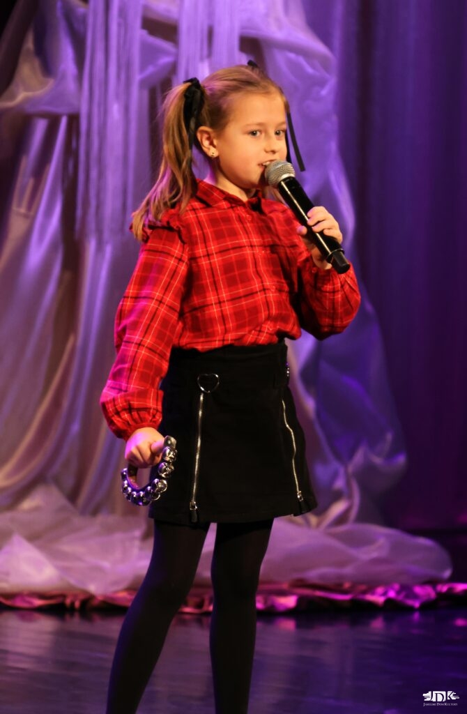 dziewczynka w czarnej spódnicy i czerwonej bluzce w kratkę