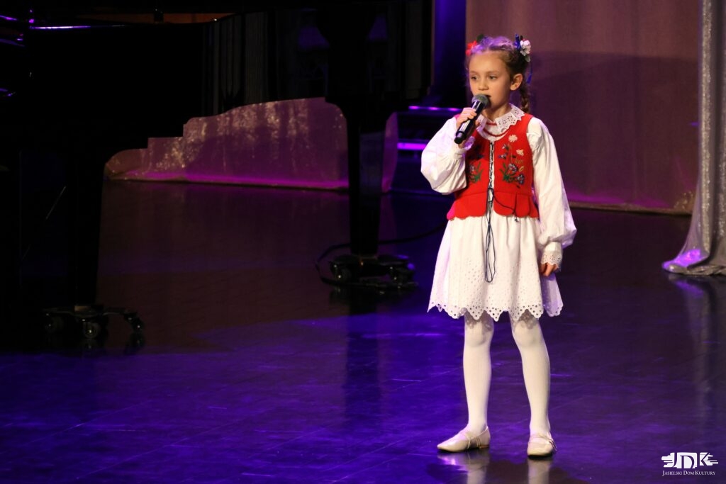 dziewczynka w ludowym stroju z kwiatami we włosach