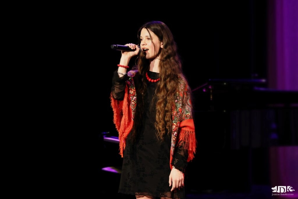 dziewczynka w czarnej sukience, czerwonych koralach i czerwonej chuście