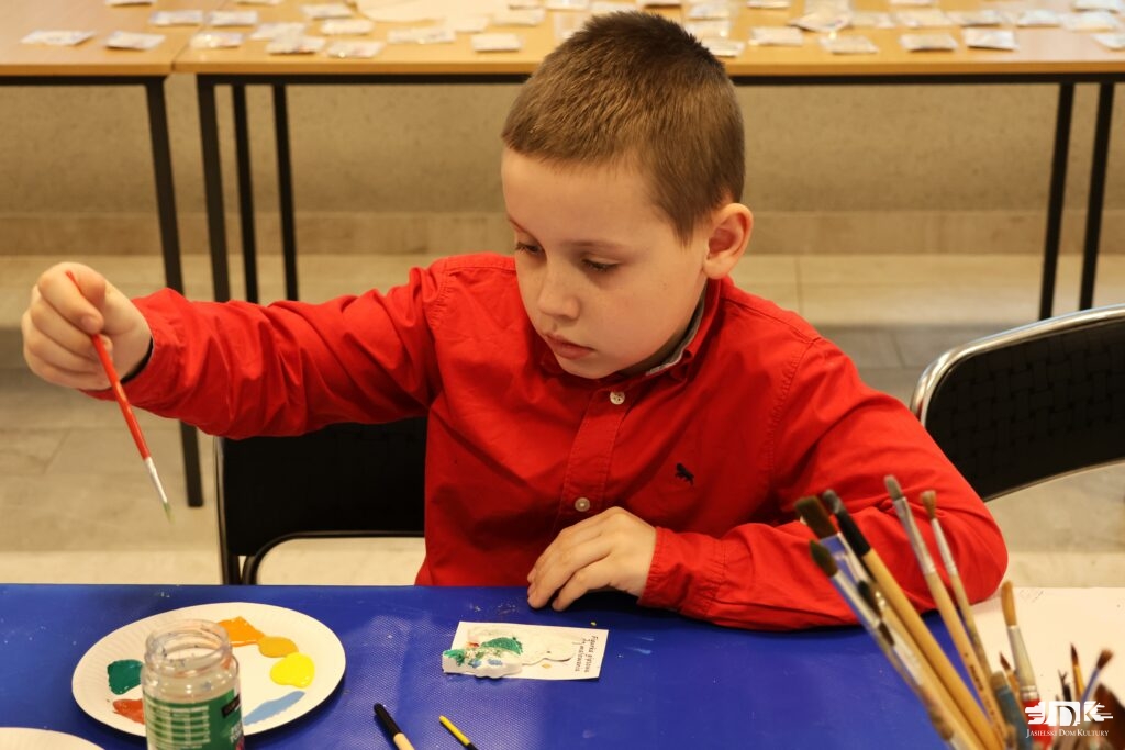 chłopiec malujący figurki gipsowe