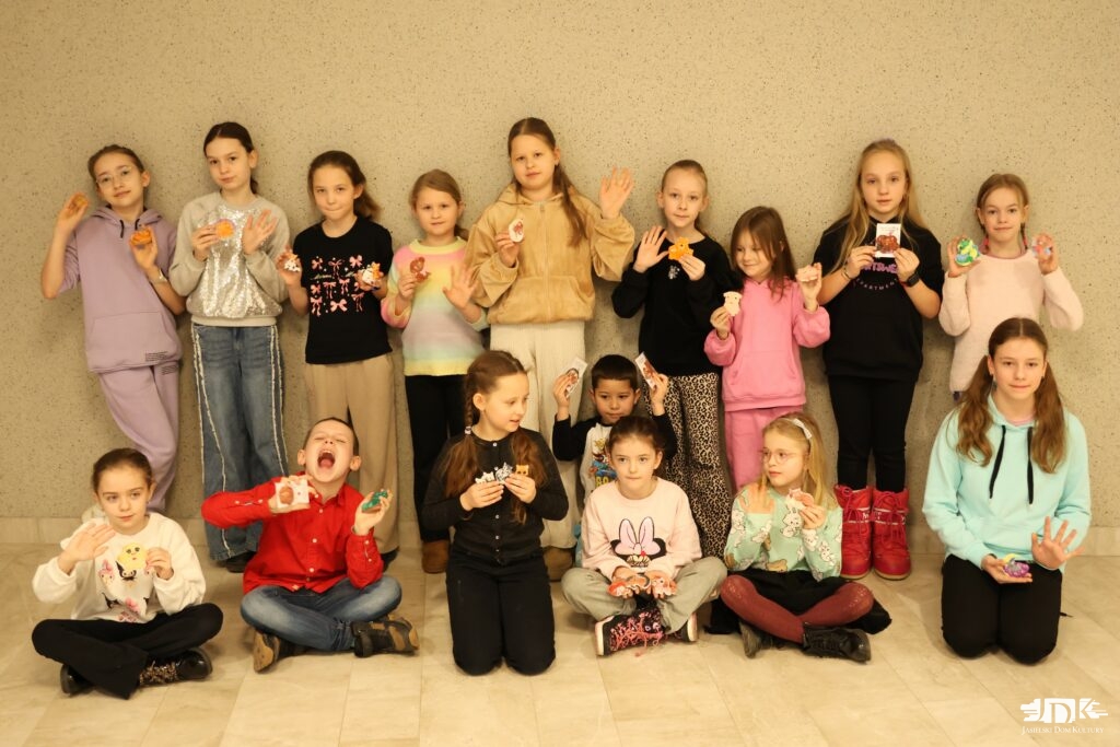 uczestnicy warsztatów prezentujący pomalowane figurki