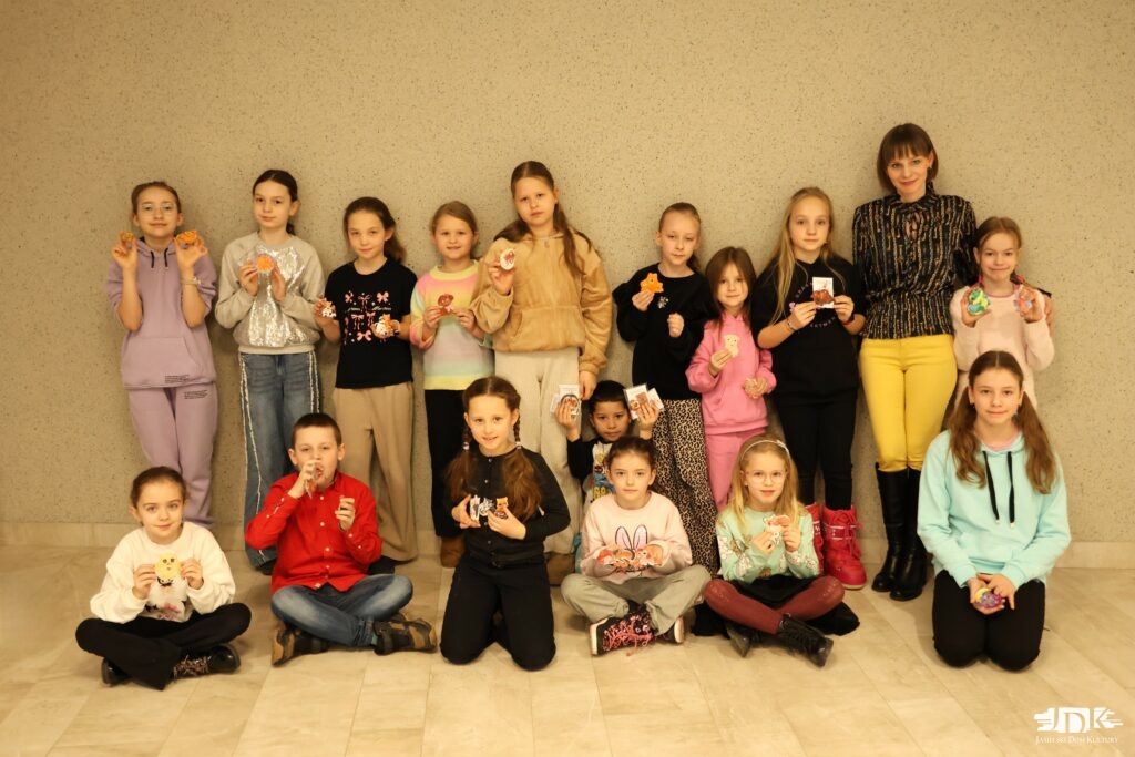 uczestnicy warsztatów prezentujący pomalowane figurki