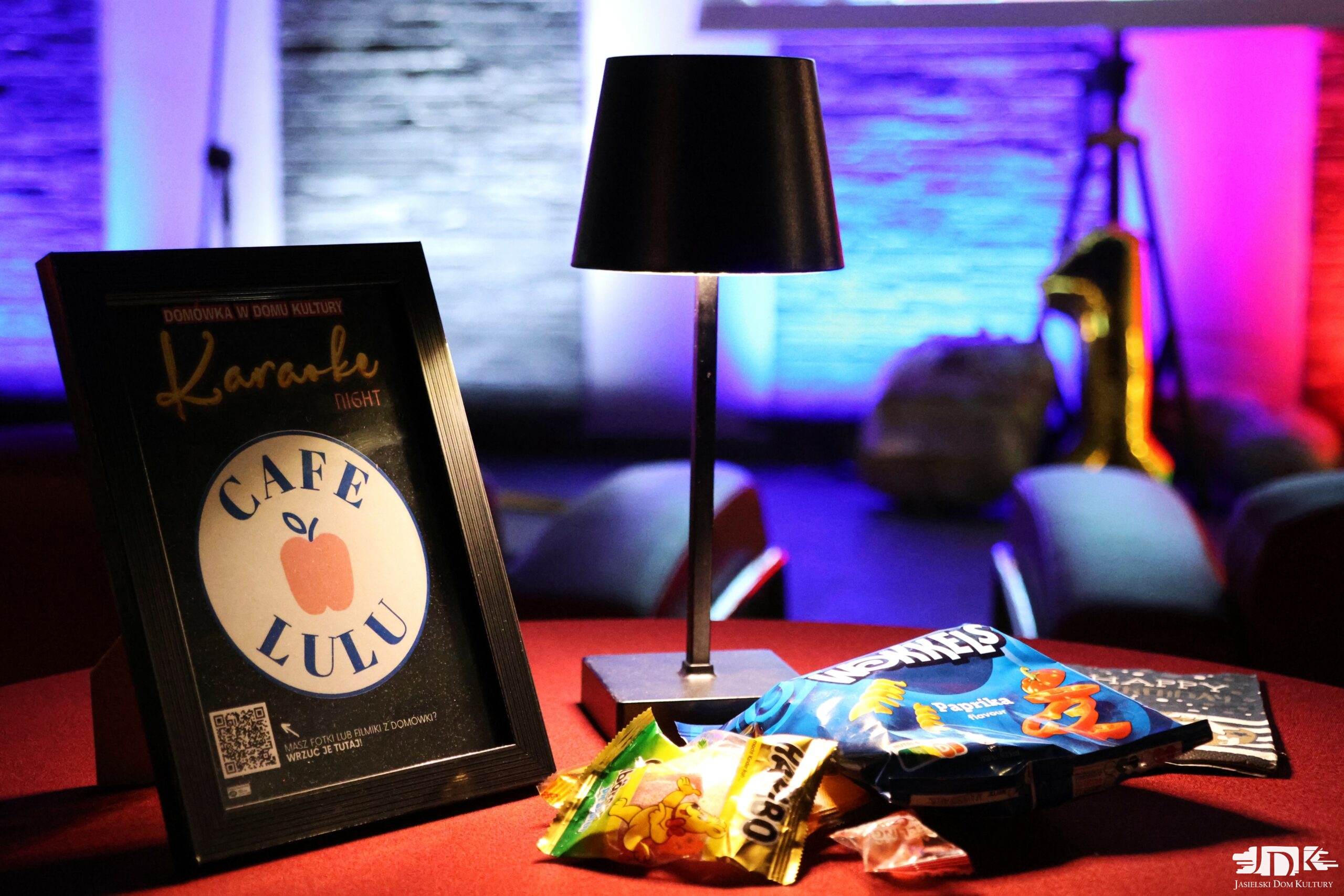 stolik z lampką, żelkami, chipsami i ramką z logo sponsora poczęstunku - CAFE LULU