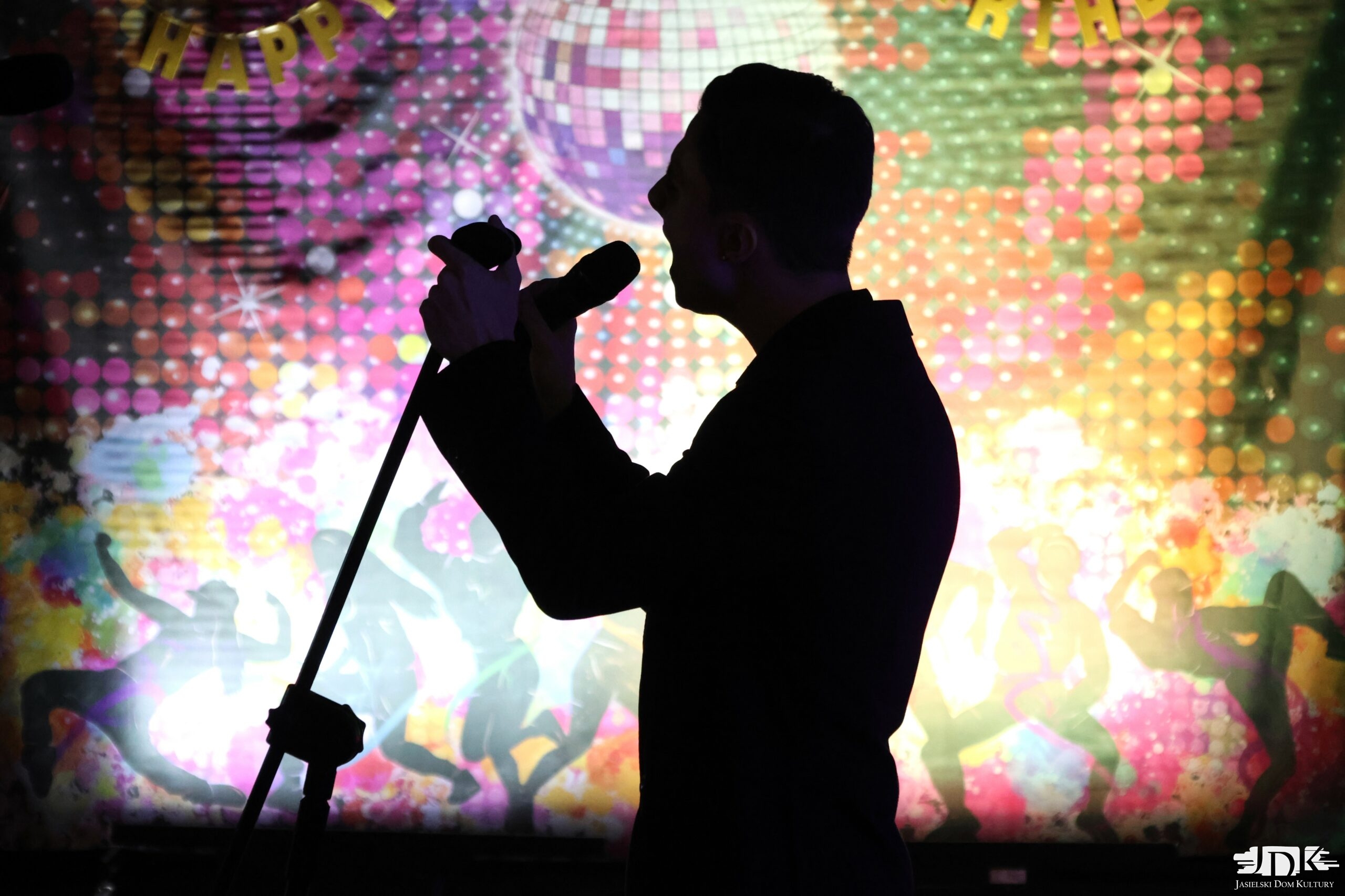 cień mężczyzny śpiewającego do mikrofonu