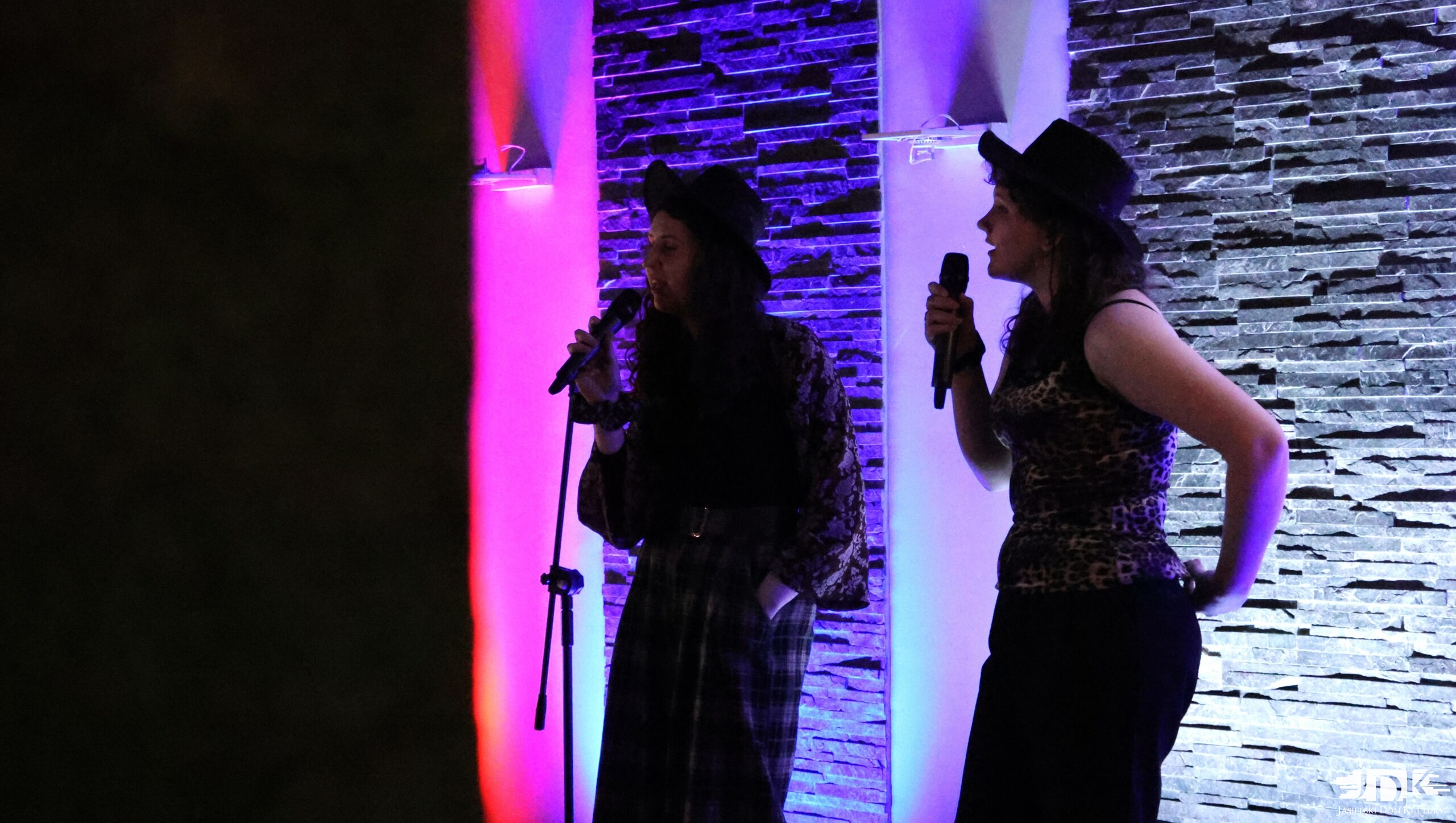 dwie dziewczyny w kapeluszach z mikrofonami