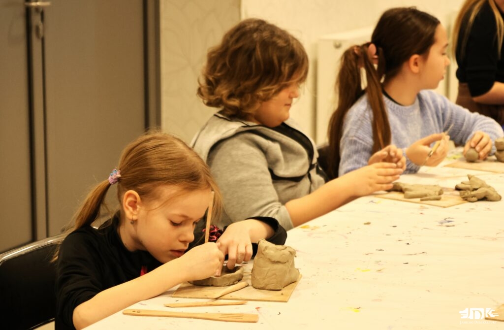 troje uczestników lepiących w glinie