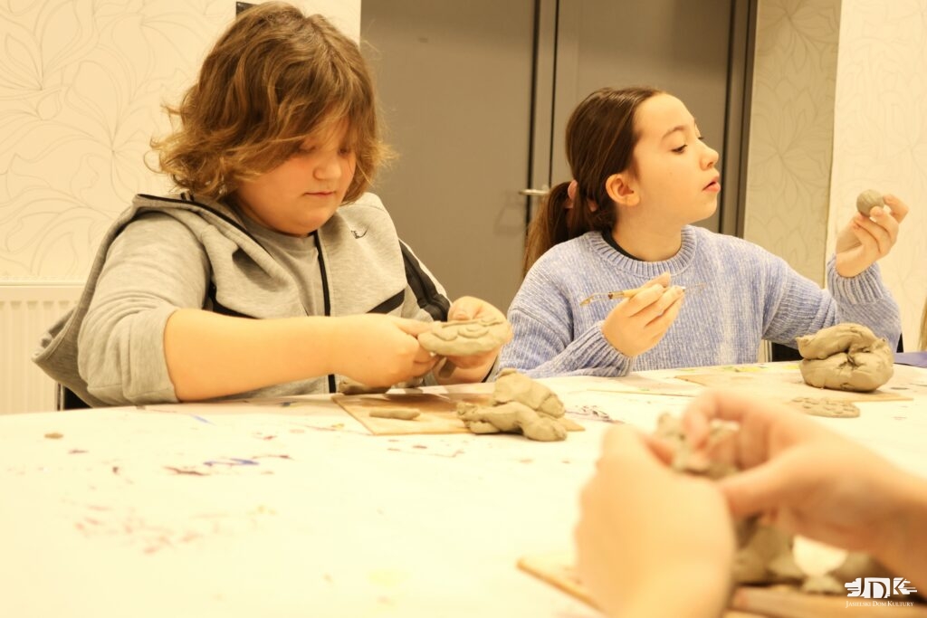 dwoje uczestników lepiących w glinie