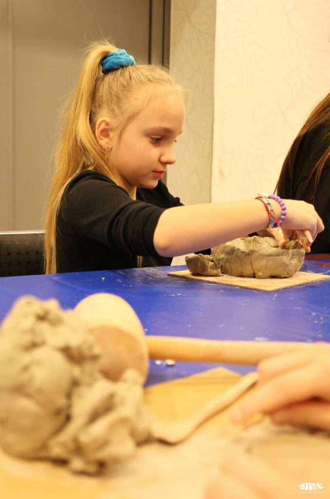 dziewczynka lepiąca w glinie