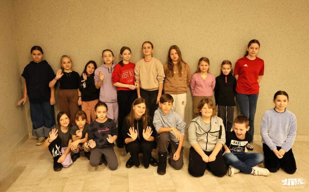 uczestnicy warsztatów w dwóch rzędach, uśmiechający się do kamery