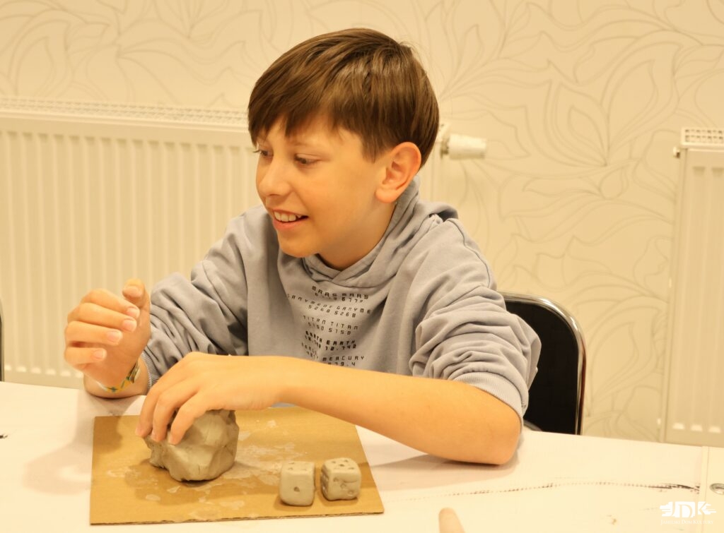 chłopiec lepiący w glinie