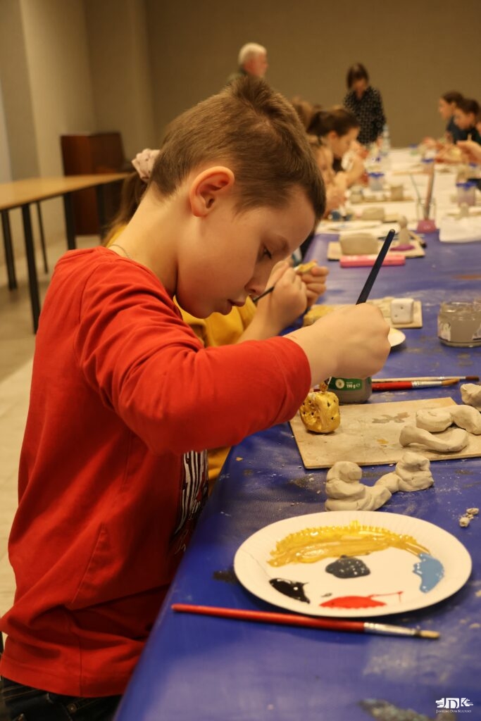 chłopiec malujący figurkę - złotą kostkę