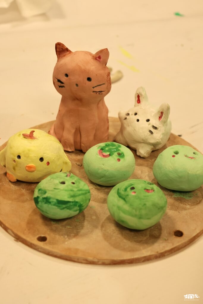 rzeźby z gliny w kolorze zielonym, brązowym, białym i żółtym