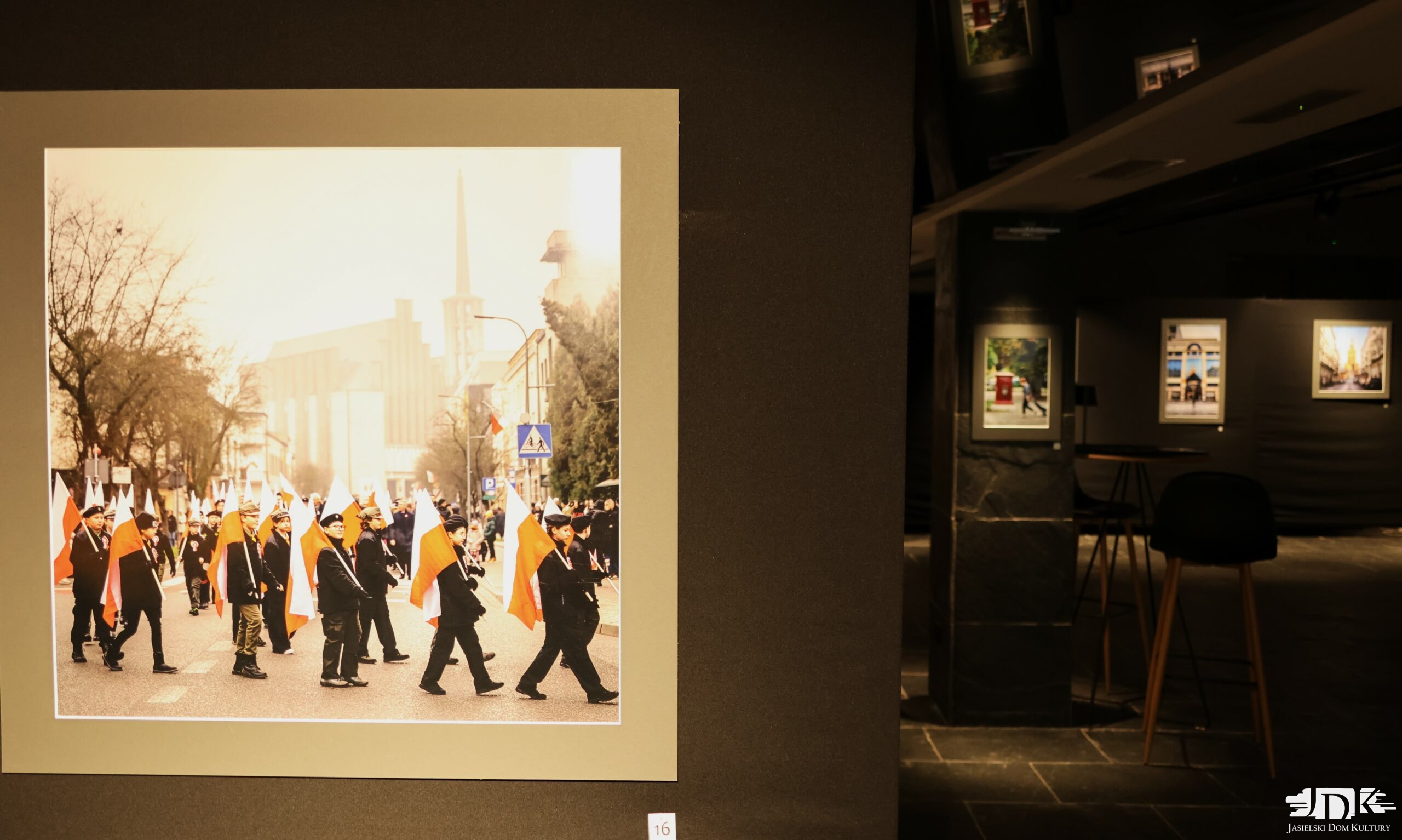 na zdjęciu fotografia przedstawiająca kościół w tle, na pierwszym planie maszerujący z flagami Polski
