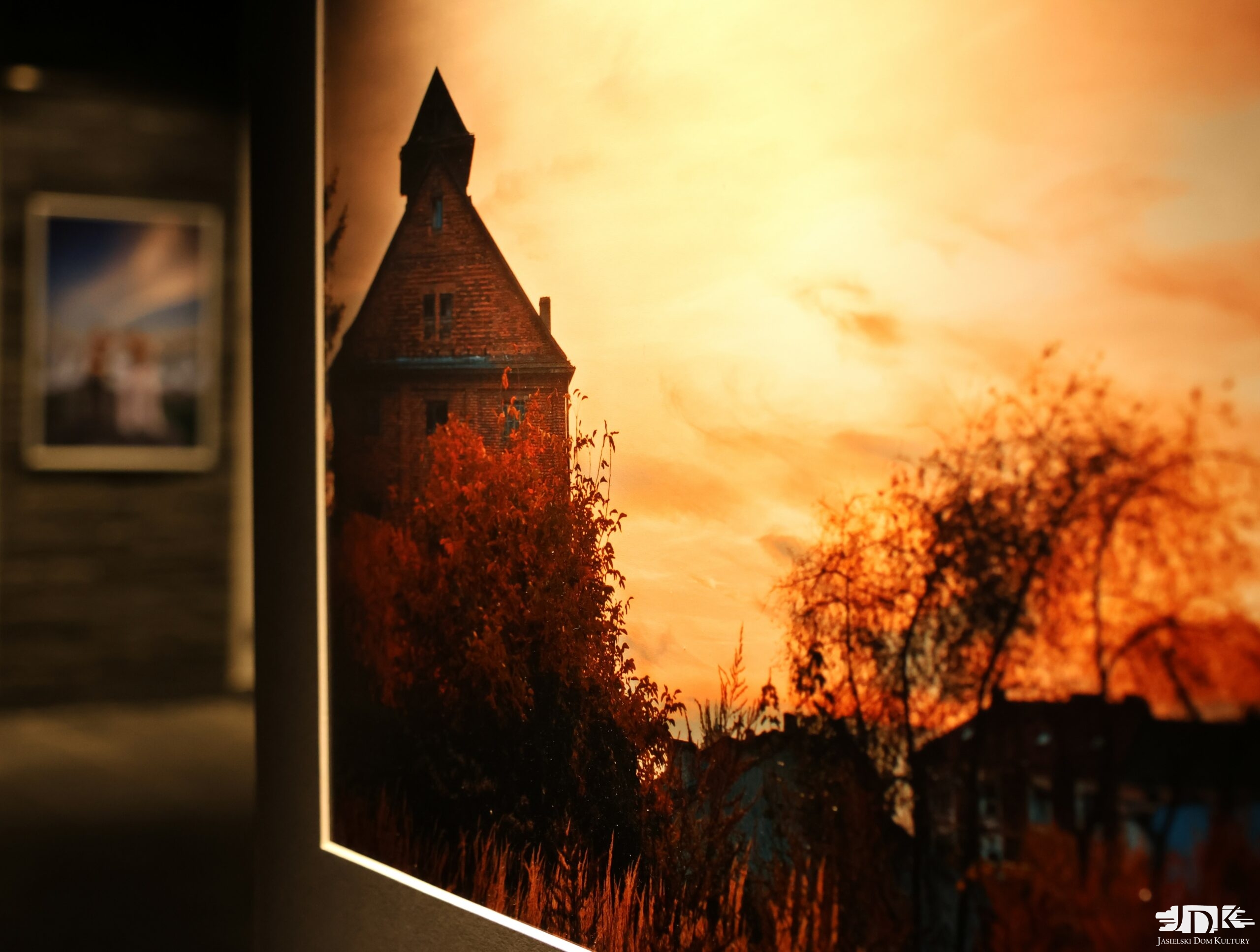 na zdjęciu fotografia przedstawiająca stary ceglany budynek, w tle zachodzące słońce