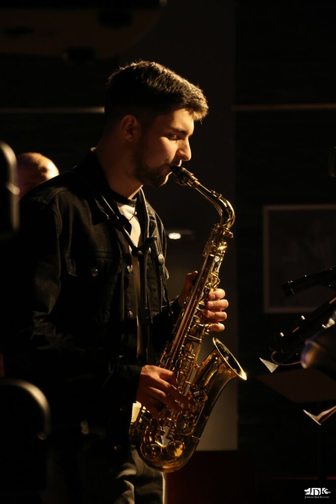 saksofonista w czarnej jeansowej kurtce