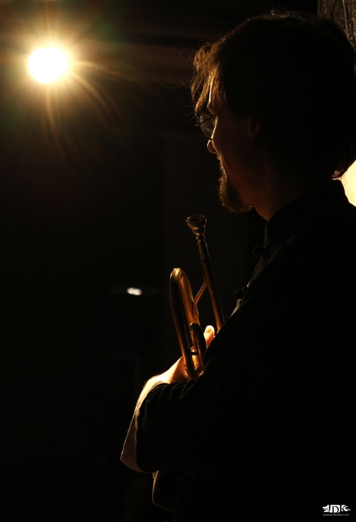 rozbłysk lampy i cień trębacza