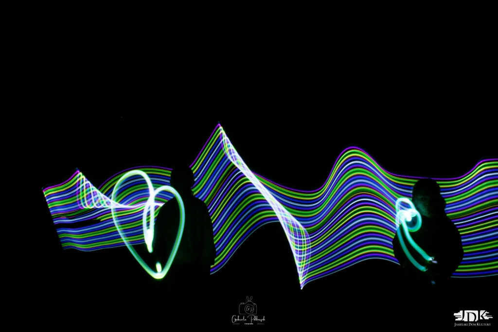 świetlne smugi i dwie osoby w ciemnych strojach