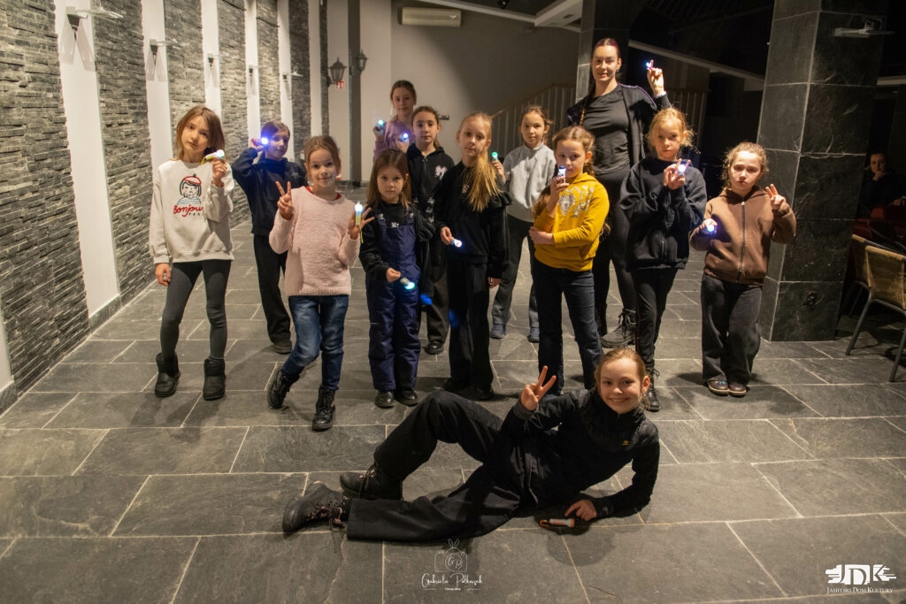 grupa dwunastu dziewczynek z latarkami oraz pani instruktorka