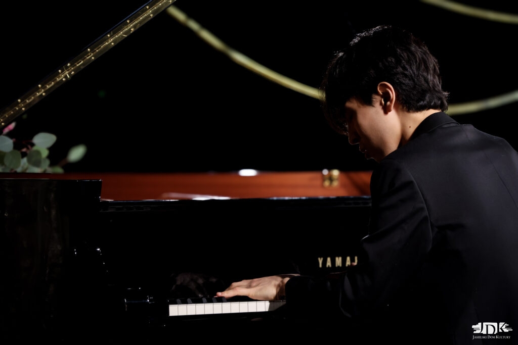 widoczna klawiatura fortepianu oraz od boku pianista