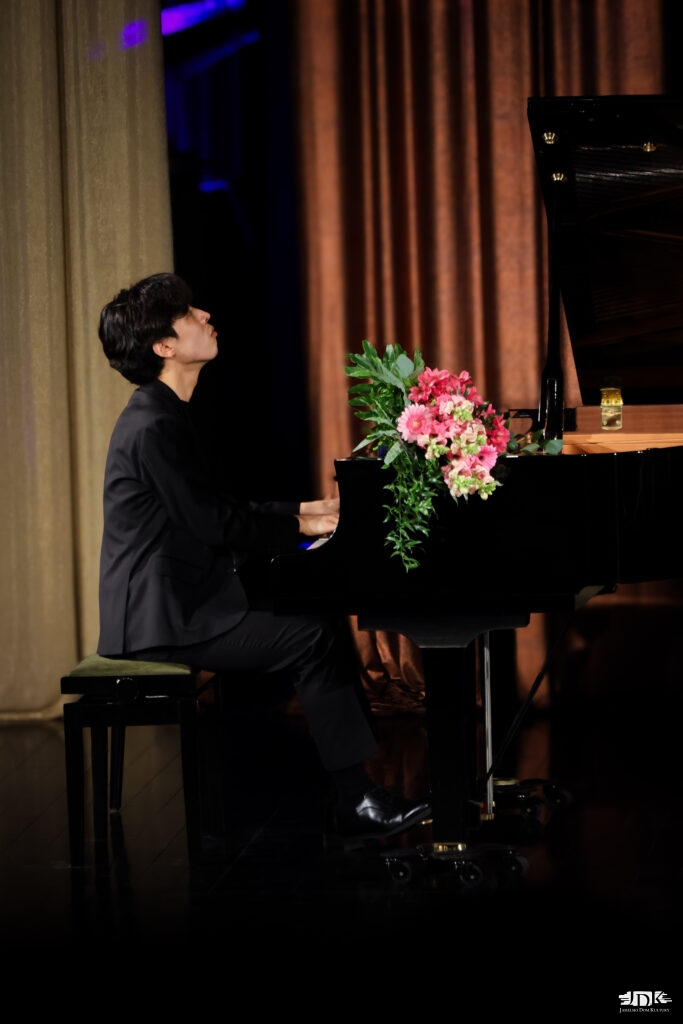 artysta grający bis z kwiatami na fortepianie