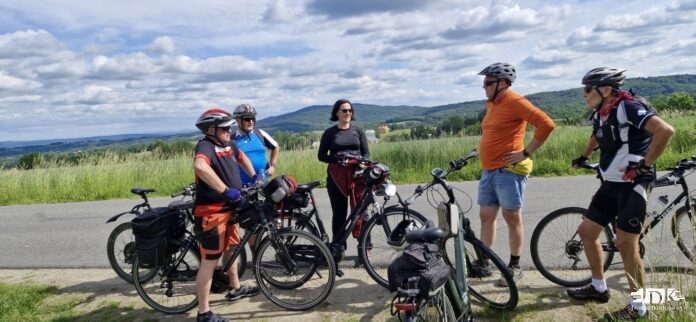 uczestnicy wycieczki rowerowej na tle pagórków